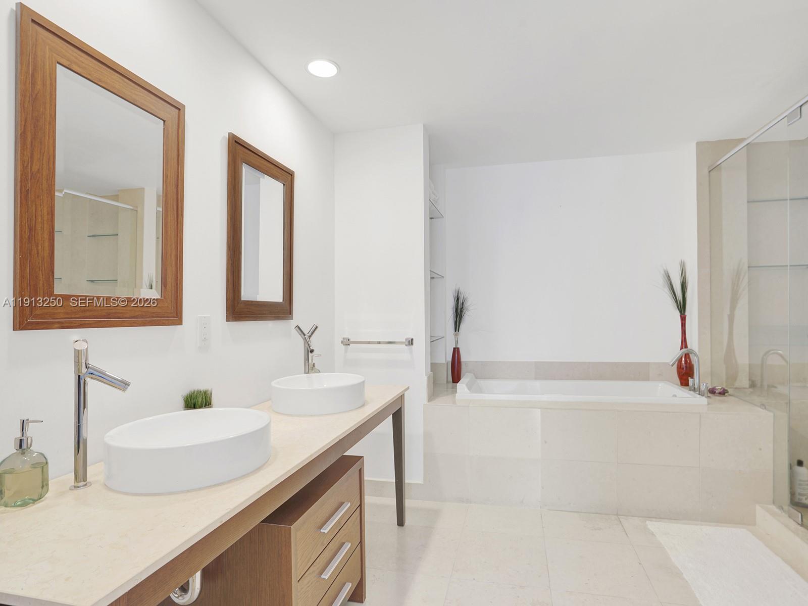 495 Brickell Avenue, Unit 2504 Miami, FL 33131 - Photo 16 of 28 a bathroom with a tub sink and mirror