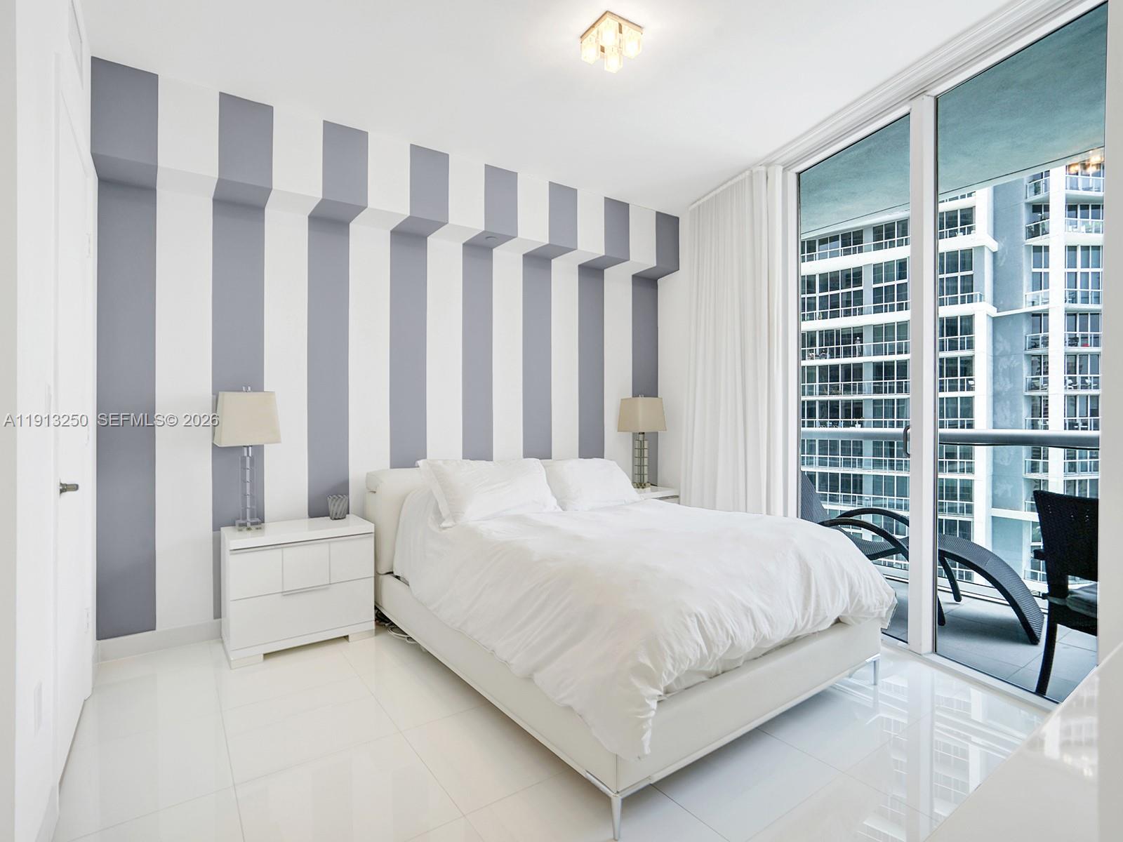 495 Brickell Avenue, Unit 2504 Miami, FL 33131 - Photo 18 of 28 a bedroom with a bed and a table in it