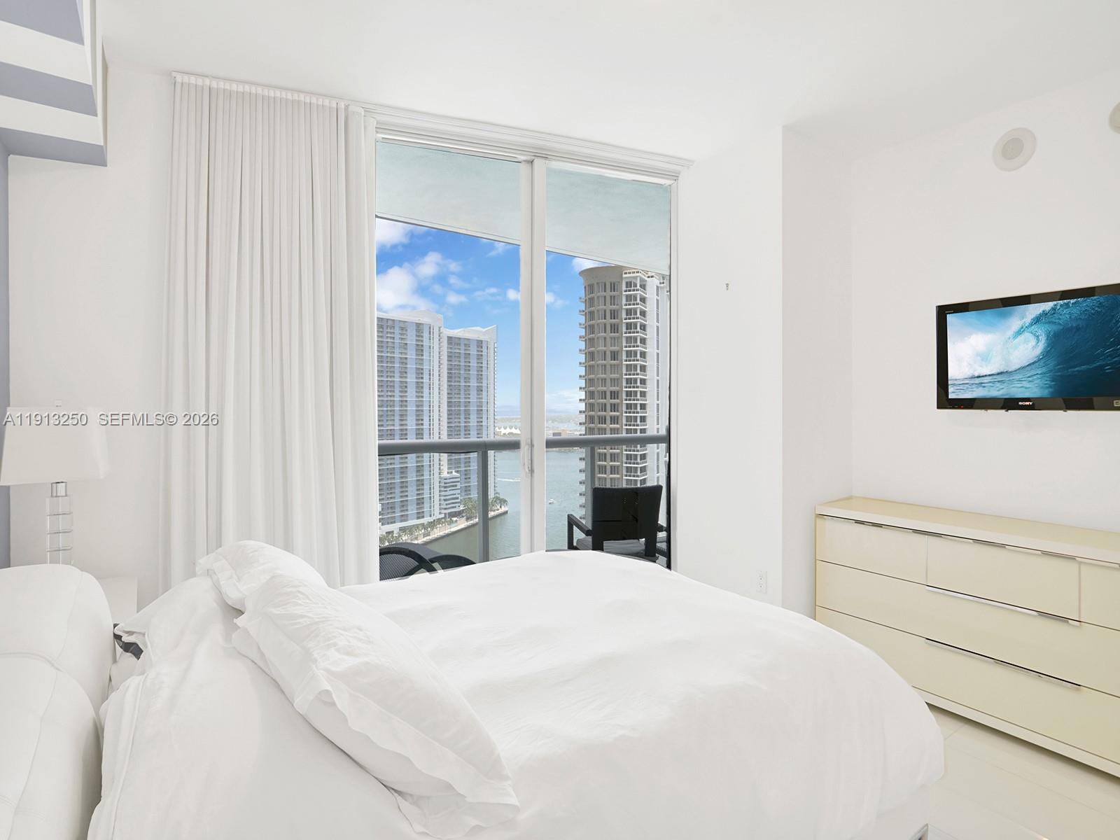 495 Brickell Avenue, Unit 2504 Miami, FL 33131 - Photo 19 of 28 a bedroom with a bed and a flat screen tv