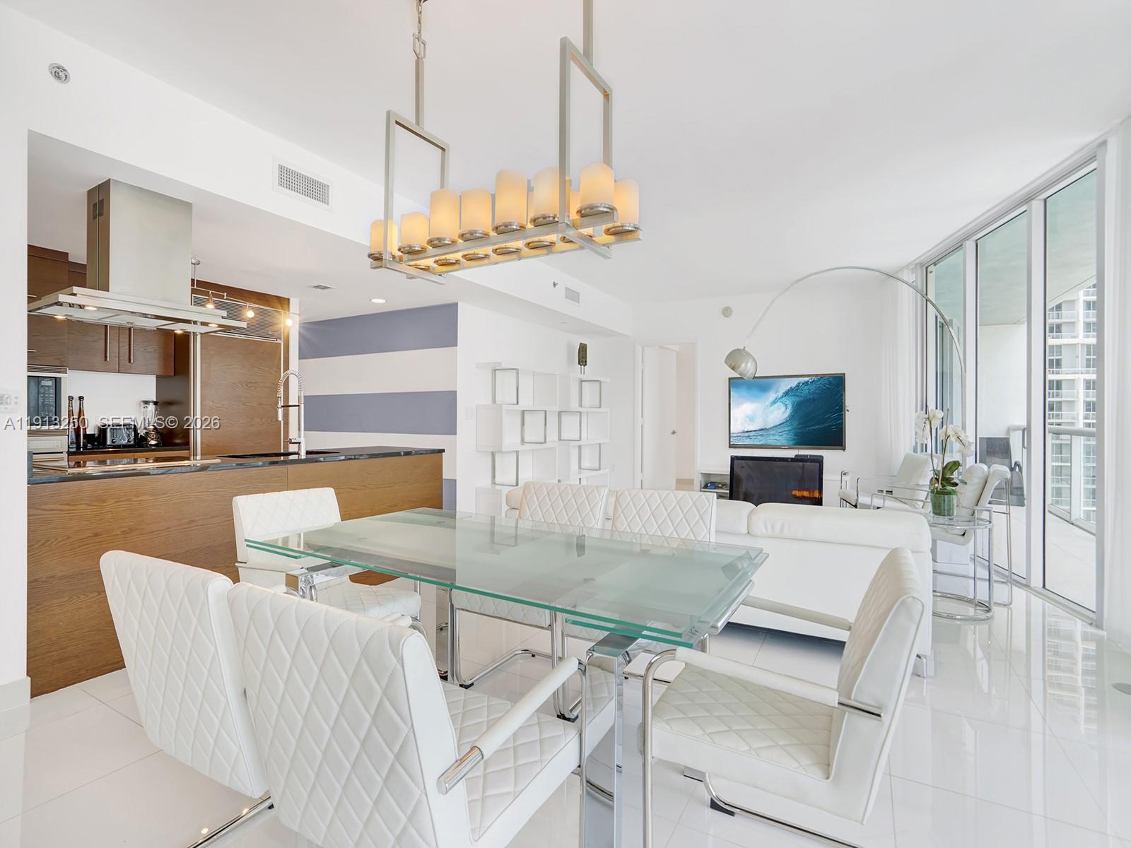 495 Brickell Avenue, Unit 2504 Miami, FL 33131 - Photo 2 of 28 a living room with dining table and a chandelier