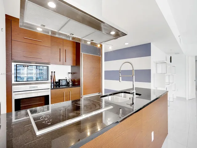 a kitchen with stainless steel appliances granite countertop a sink a counter space and cabinets