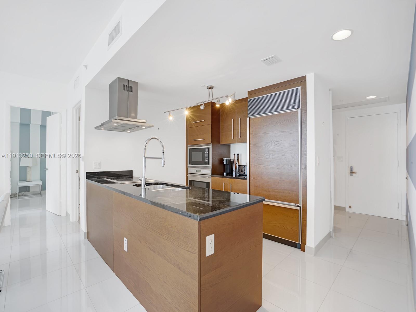 495 Brickell Avenue, Unit 2504 Miami, FL 33131 - Photo 4 of 28 a kitchen with stainless steel appliances granite countertop a sink and a refrigerator