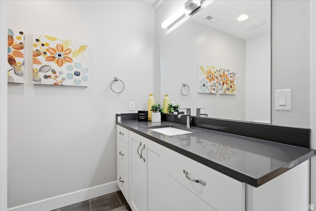 21 Pier Place Tooele, UT 84074 - Photo 47 of 112 Vanity featuring a dark gray countertop with integrated sink, chrome faucet, and white cabinetry with brushed nickel hardware