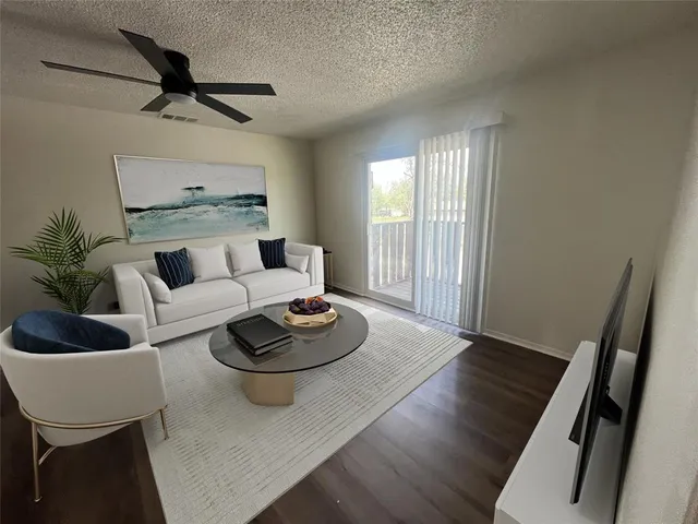 a living room with furniture and a wooden floor