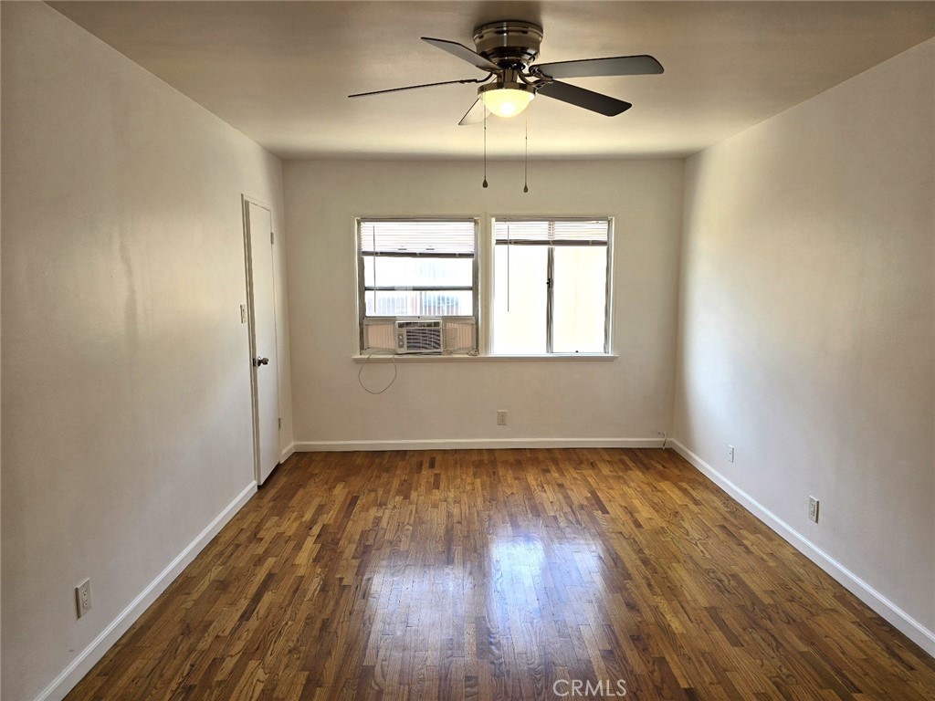 12503 Grevillea Avenue, Unit C Hawthorne, CA 90250 - Photo 3 of 13 an empty room with wooden floor chandelier fan and windows