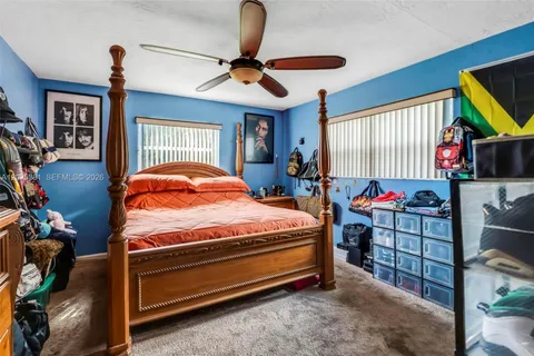 a bedroom with a bed a dresser and flat screen tv