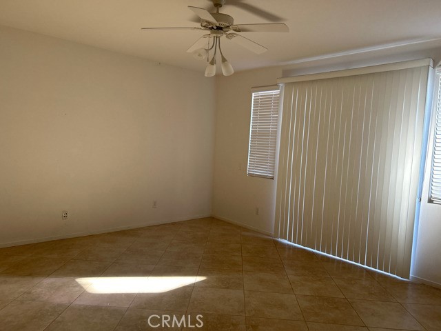 an empty room with a ceiling fan and window