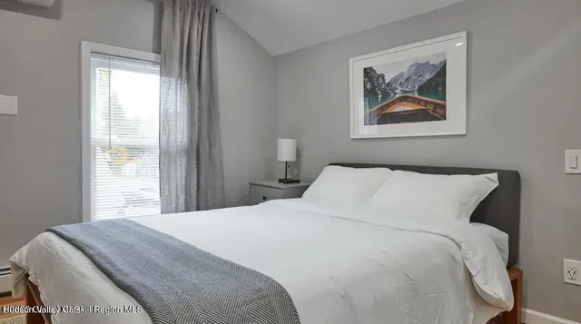 a bedroom with a bed and a painting on the wall