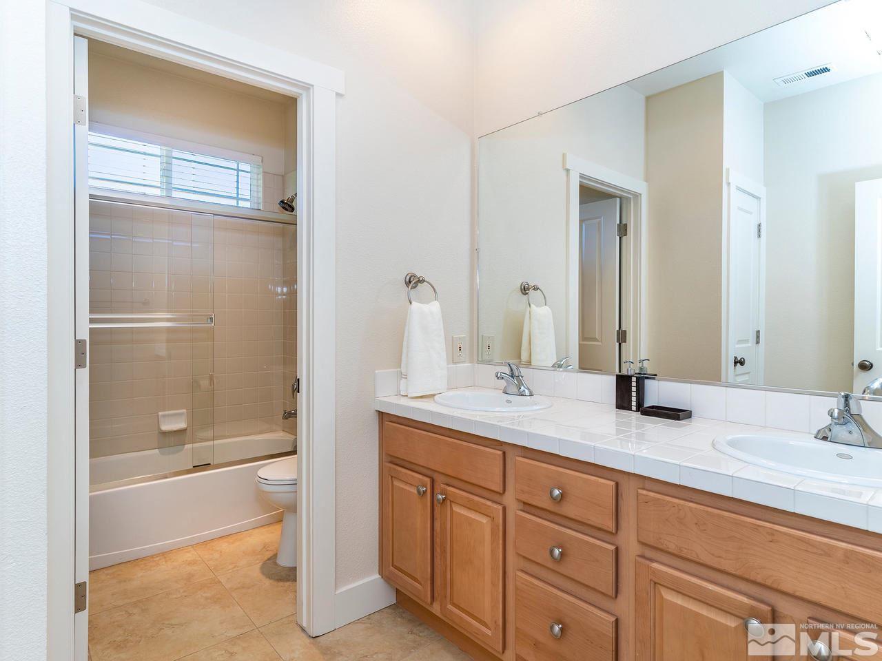 5021 Fall Colors Court Reno, NV 89519 - Photo 23 of 26 a bathroom with a granite countertop sink mirror and a bathtub