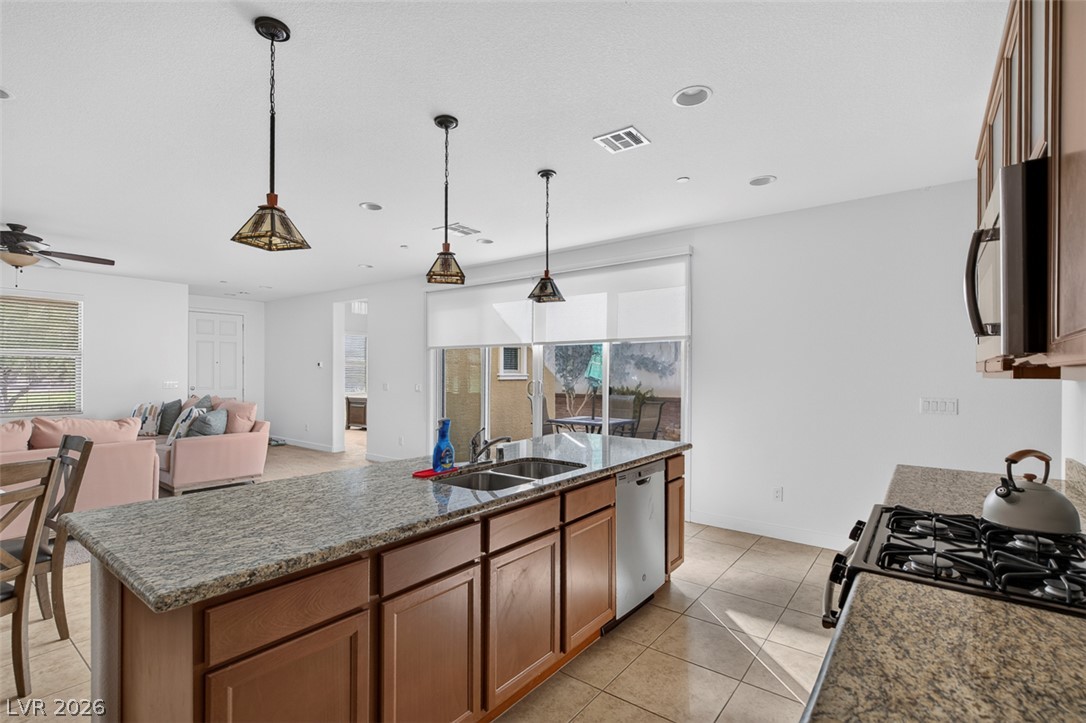1100 East Sunset Road Henderson, NV 89011 - Photo 13 of 58 A well-appointed kitchen island with ample counter space and integrated sink overlooks the inviting living area.