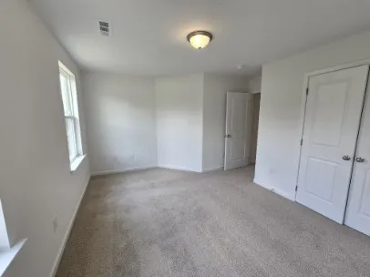an empty room with windows and closet