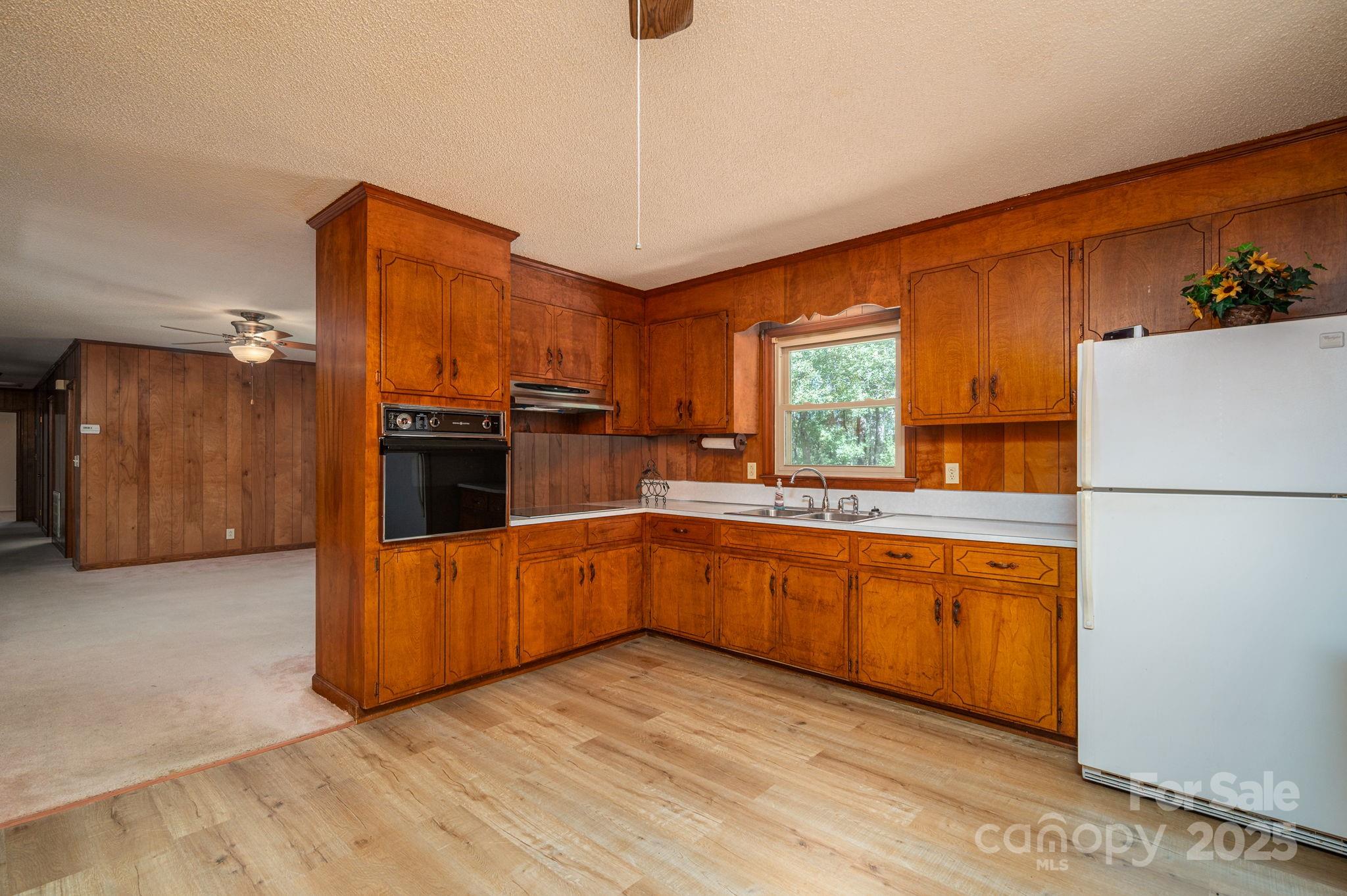 215 Suncrest Road Cherryville, NC 28021 - Photo 10 of 26 a kitchen with stainless steel appliances granite countertop a refrigerator a sink dishwasher a stove with wooden cabinets and floor