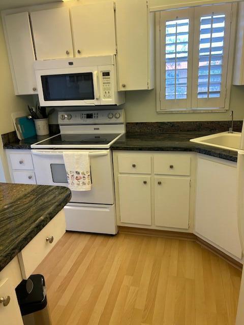 1955 Southwest Palm City Road, Unit H Stuart, FL 34994 - Photo 5 of 22 a kitchen with stainless steel appliances granite countertop a stove a sink and a microwave