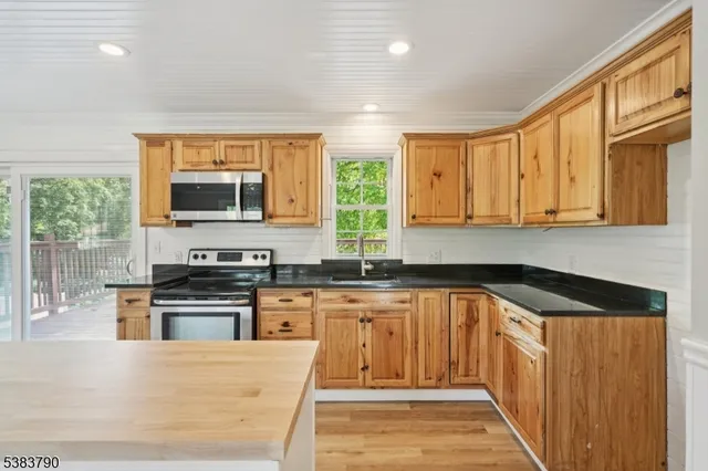 a kitchen with stainless steel appliances granite countertop a stove a sink and a microwave