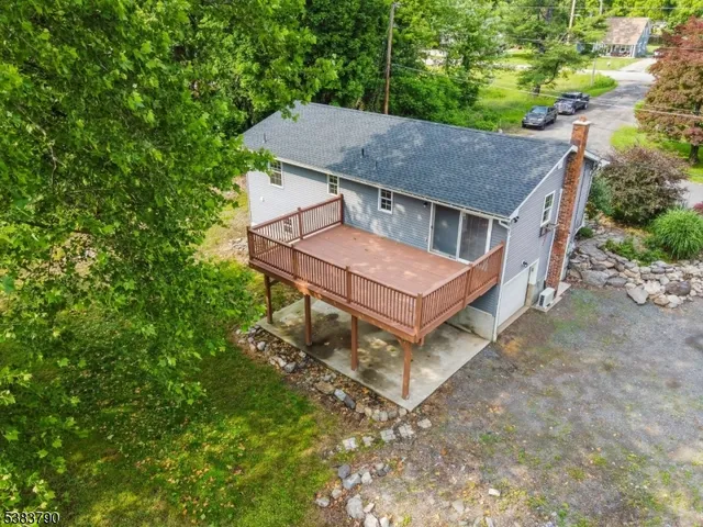 aerial view of a house with a yard balcony and wooden fence