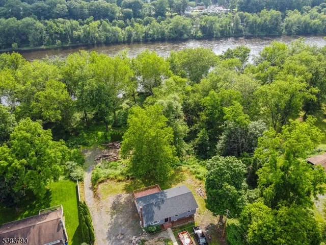 an aerial view of a house with a yard and lake view