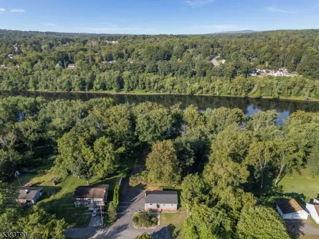 an aerial view of a residential houses with outdoor space and trees