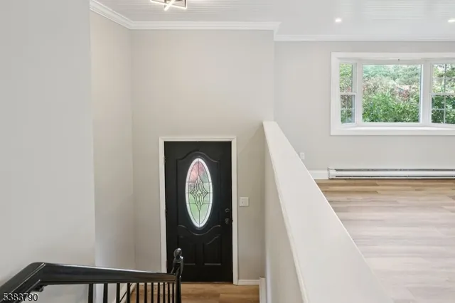 a view of a hallway with wooden floor and a window