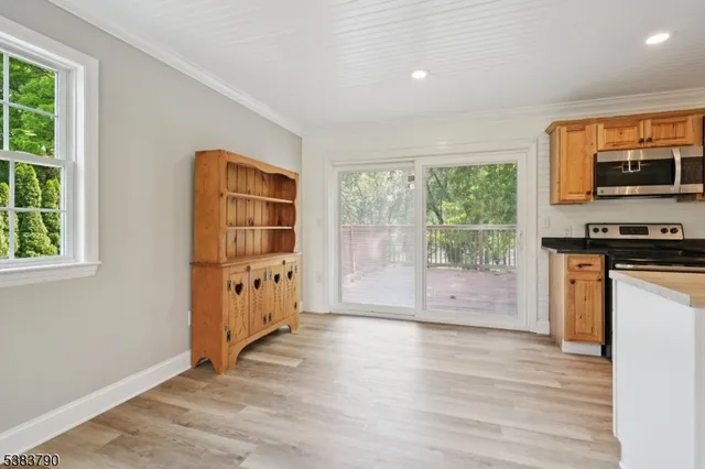 a view of a kitchen with fridge and wooden floor