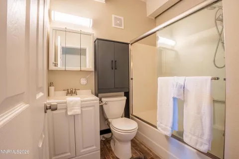 a spacious bedroom with a bed and a dresser next to a window