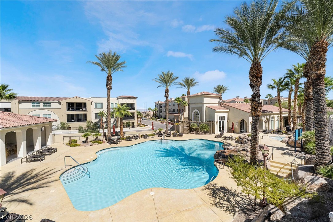 2555 Hampton Road, Unit 10202 Henderson, NV 89052 - Photo 35 of 35 A sparkling community swimming pool rests surrounded by towering palms and Mediterranean architectural design.