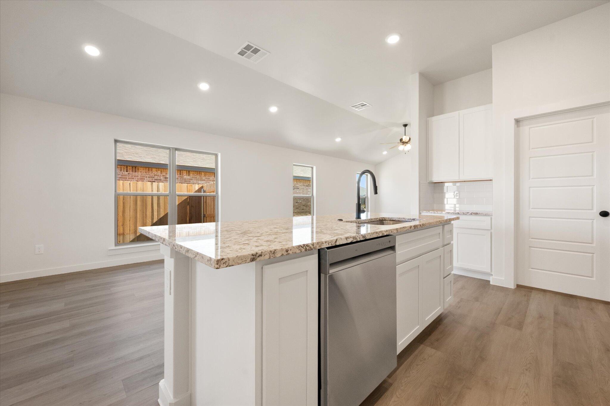 7214 8th Street Lubbock, TX 79416 - Photo 11 of 23 a kitchen with granite countertop a sink and cabinets