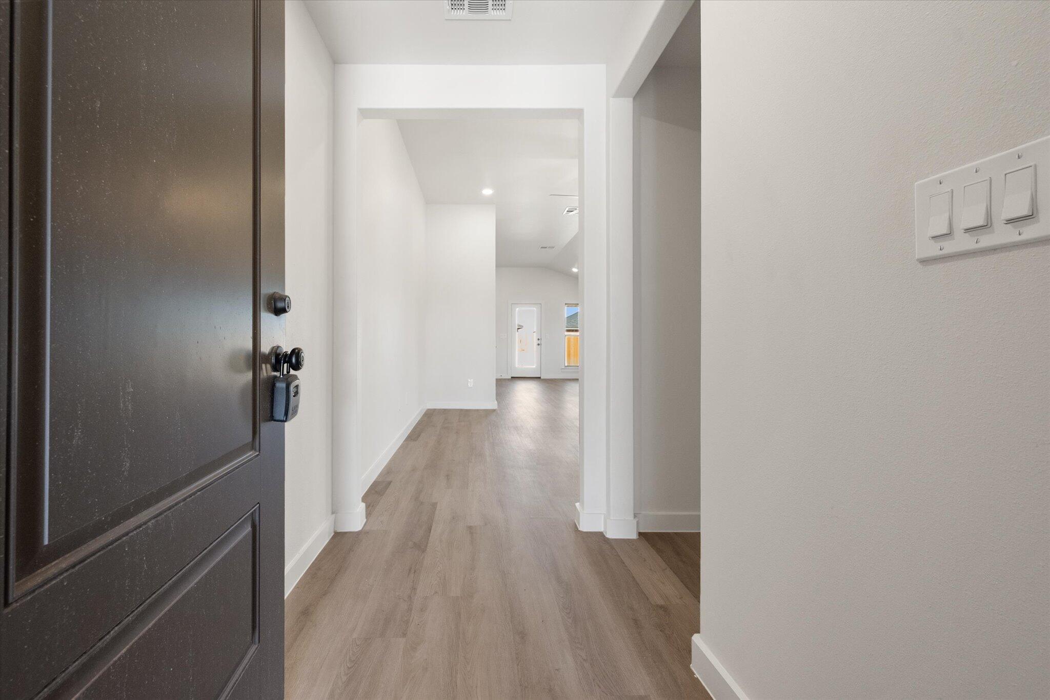 7214 8th Street Lubbock, TX 79416 - Photo 3 of 23 a view of a hallway with wooden floor and staircase
