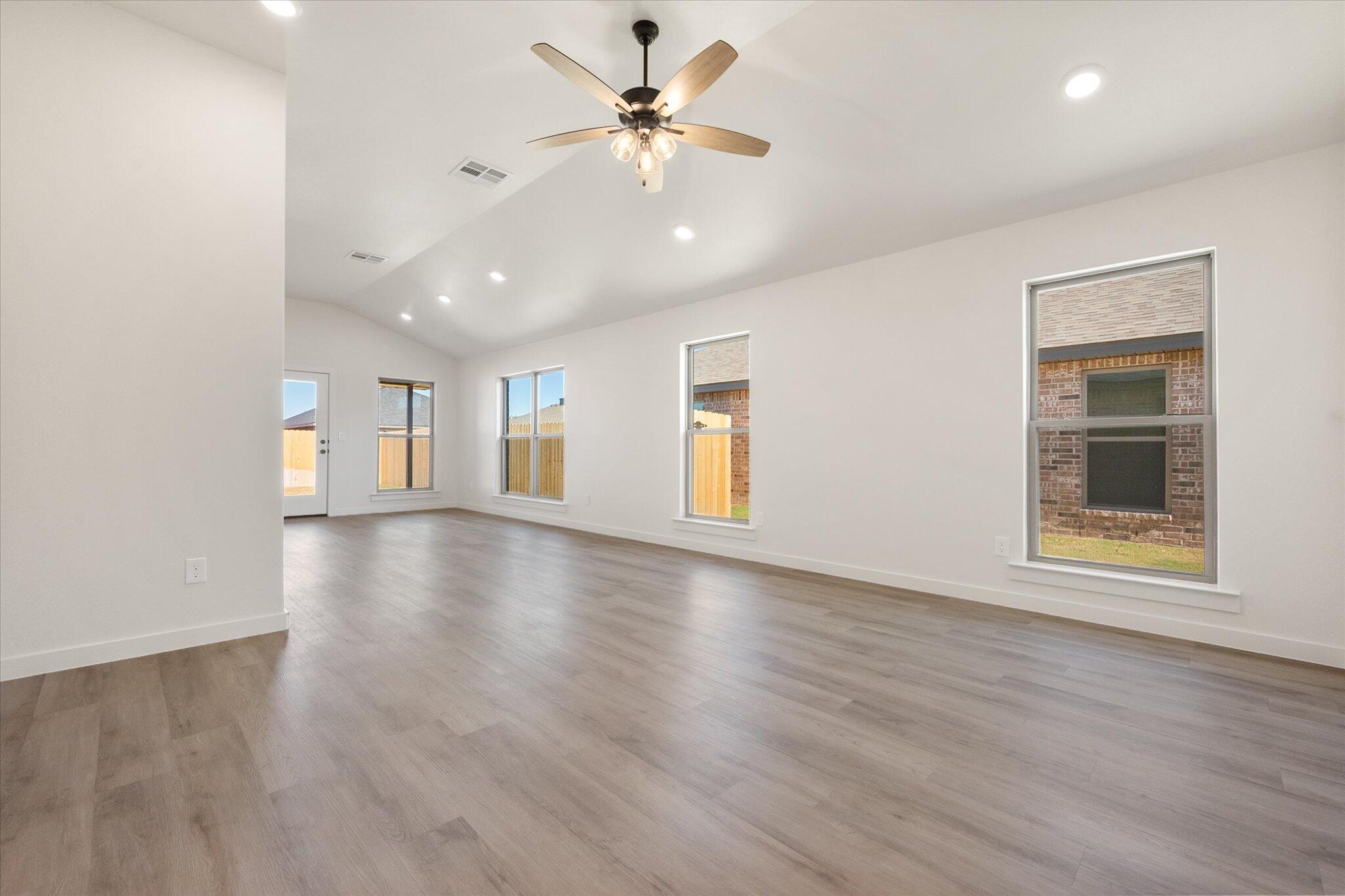 7214 8th Street Lubbock, TX 79416 - Photo 4 of 23 a view of an empty room with window and wooden floor