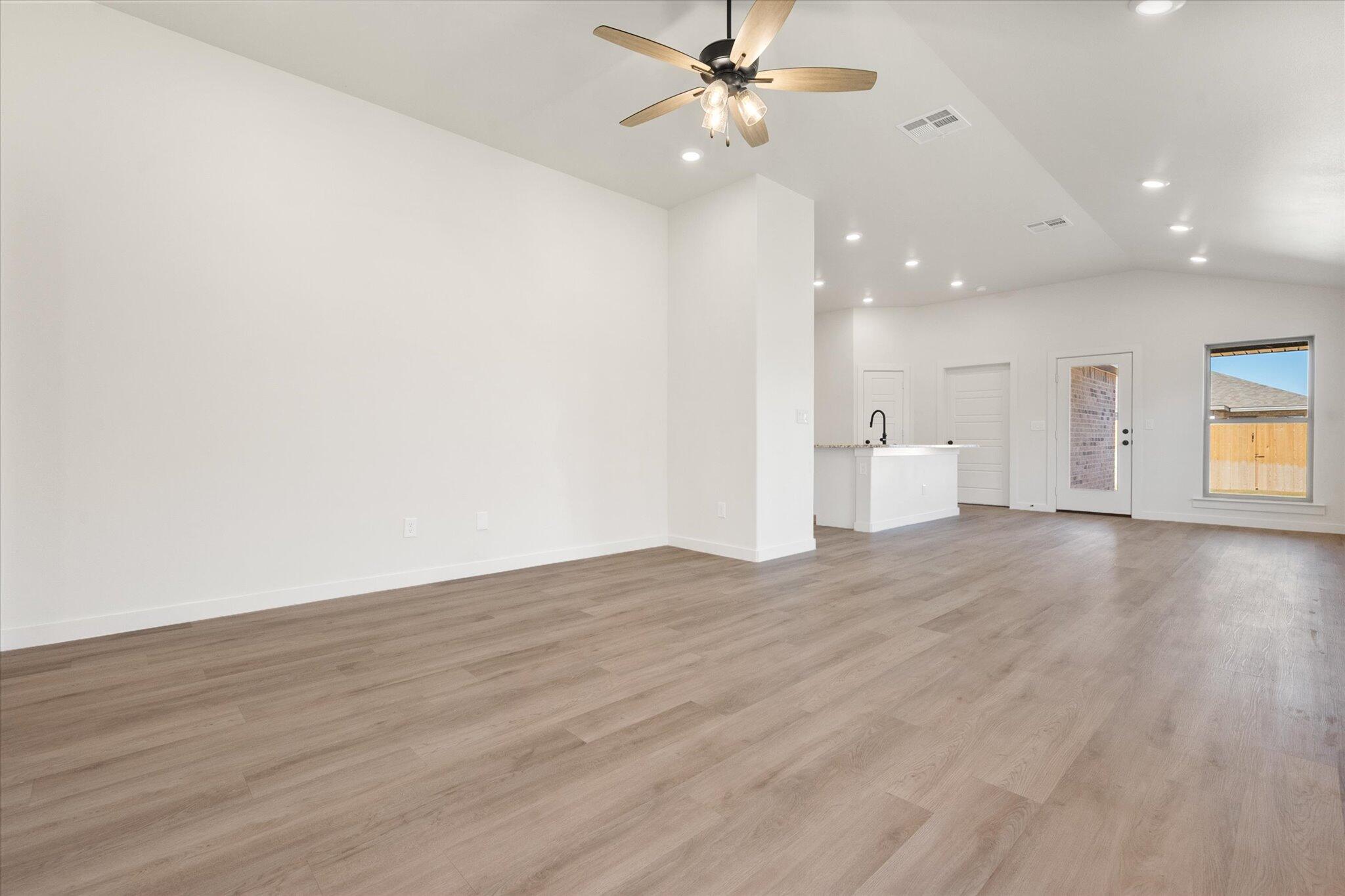 7214 8th Street Lubbock, TX 79416 - Photo 5 of 23 a view of a livingroom with a ceiling fan window and wooden floor