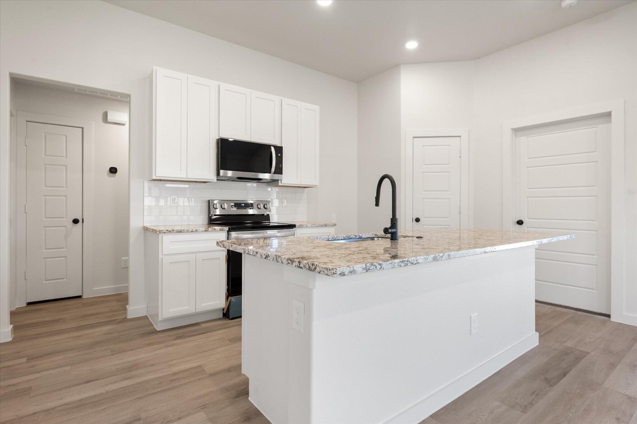 7214 8th Street Lubbock, TX 79416 - Photo 7 of 23 a kitchen with a sink and a stove top oven