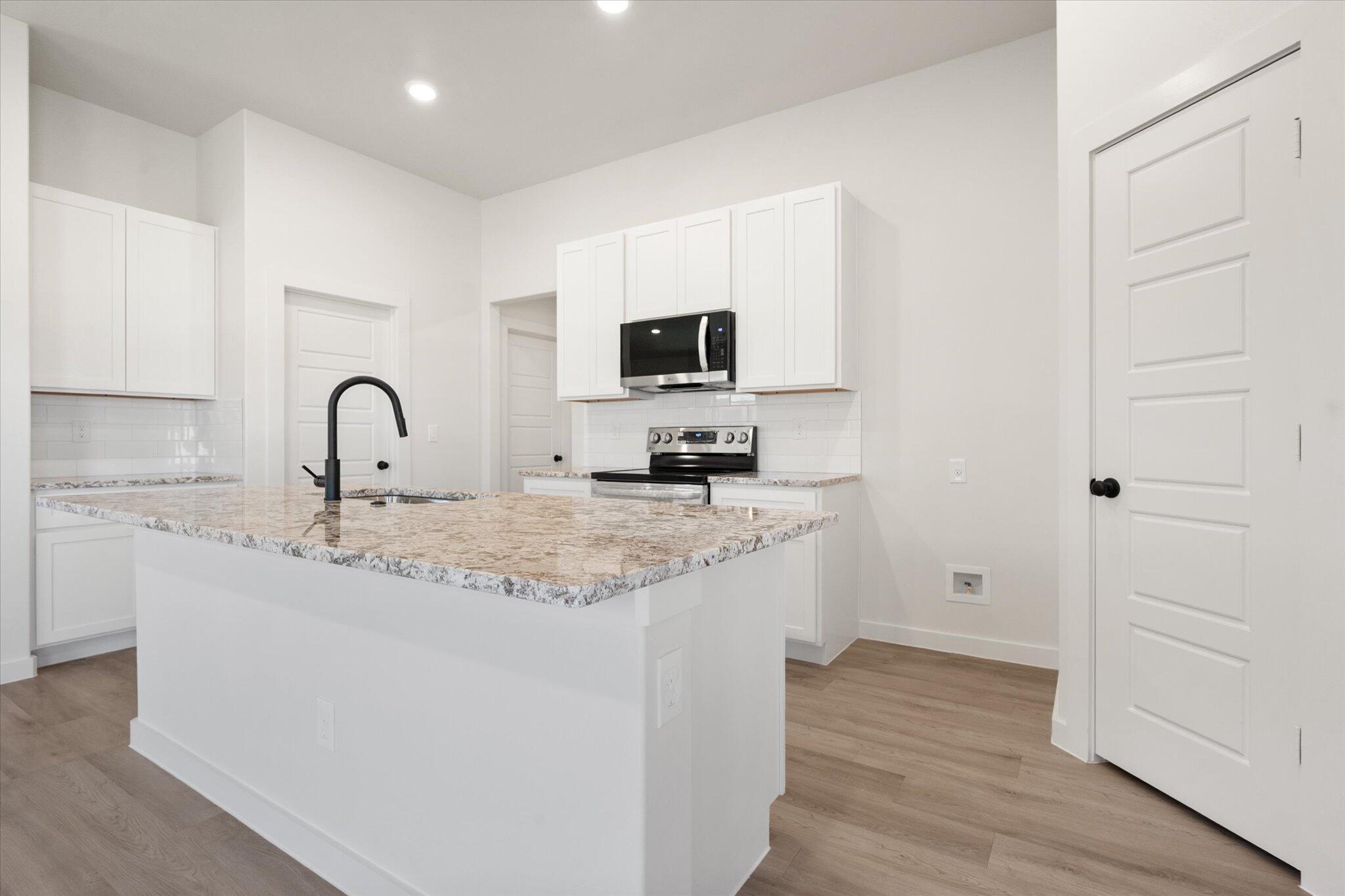 7214 8th Street Lubbock, TX 79416 - Photo 9 of 23 a kitchen with a sink and a stove top oven