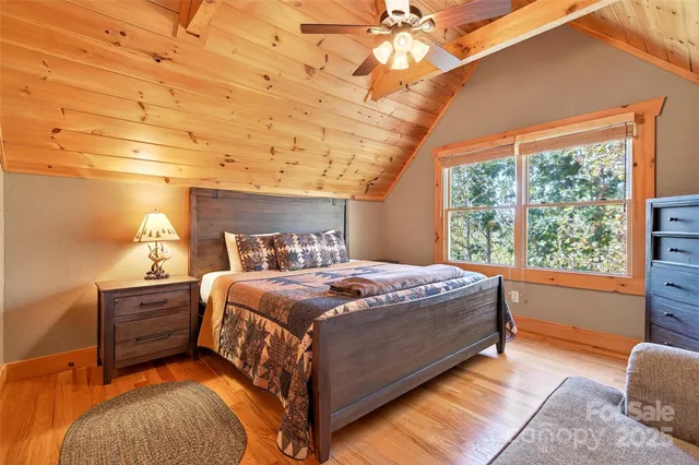 a bed sitting in a spacious bedroom next to a window
