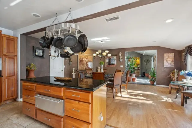 a kitchen with stainless steel appliances granite countertop a sink a stove and a wooden floors