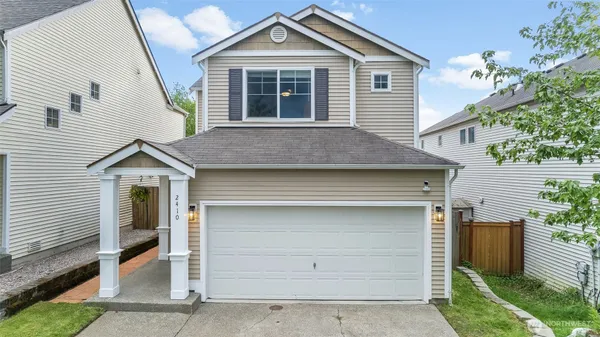 a front view of a house with a garage and balcony