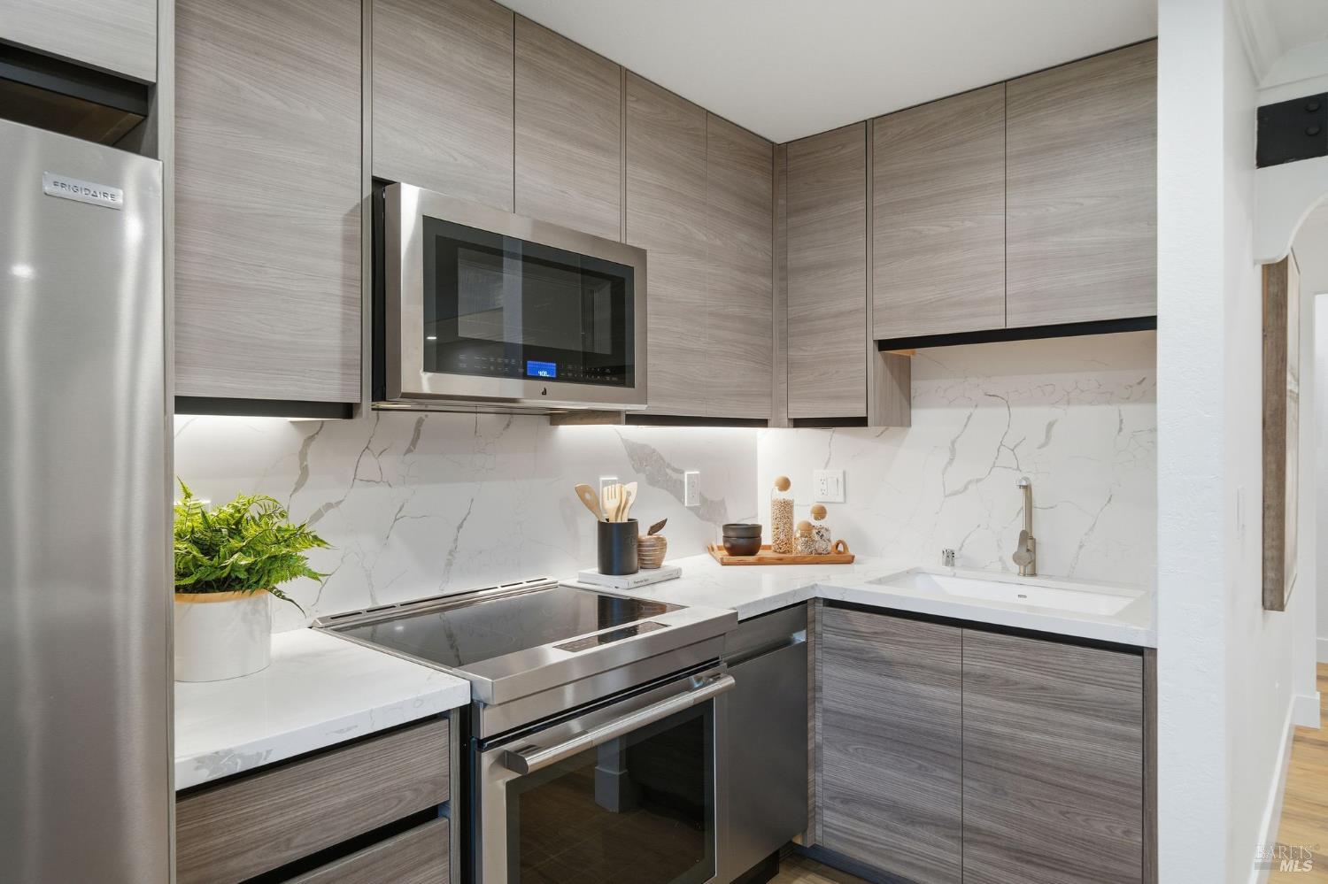 116 Stanford Way Sausalito, CA 94965 - Photo 12 of 37 a kitchen with stainless steel appliances a sink a stove a microwave a sink and cabinets