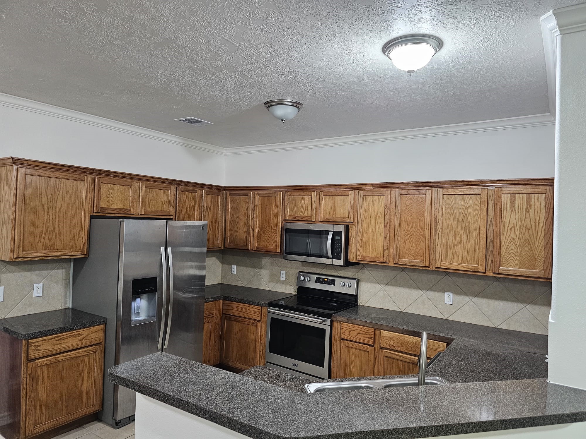 4611 B Briscoe Street Houston, TX 77051 - Photo 3 of 10 a kitchen with a refrigerator stove and microwave