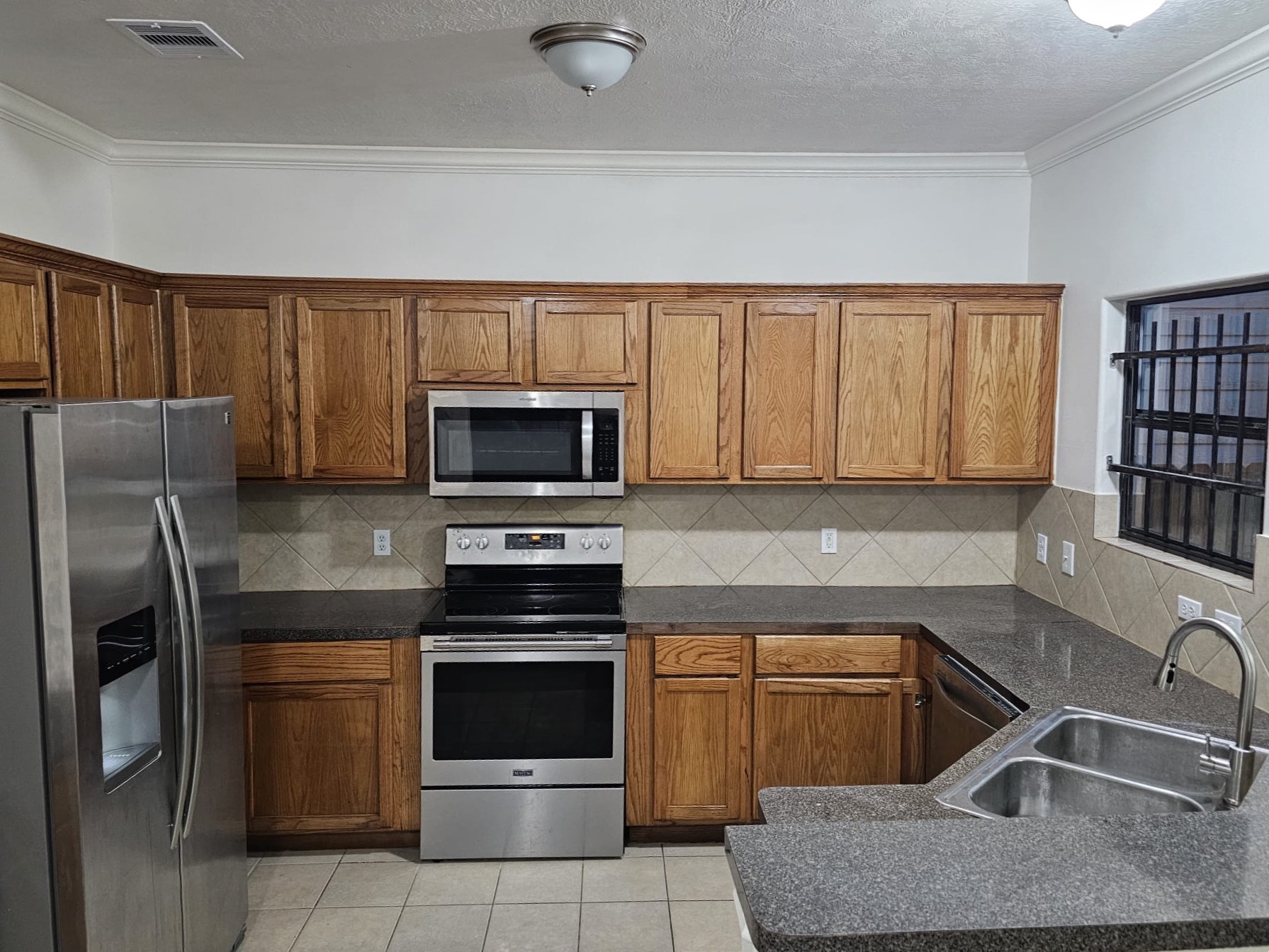 4611 B Briscoe Street Houston, TX 77051 - Photo 4 of 10 a kitchen with granite countertop a stove sink and refrigerator
