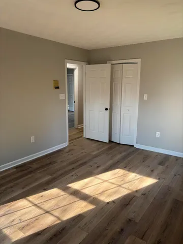 a view of a room with wooden floor and white walls