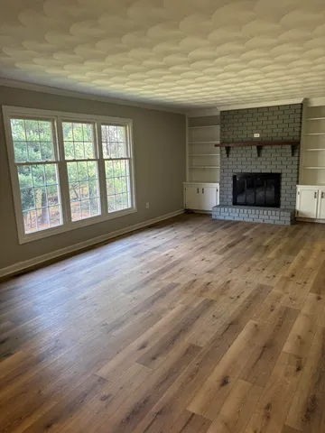 a view of empty room with wooden floor and fireplace