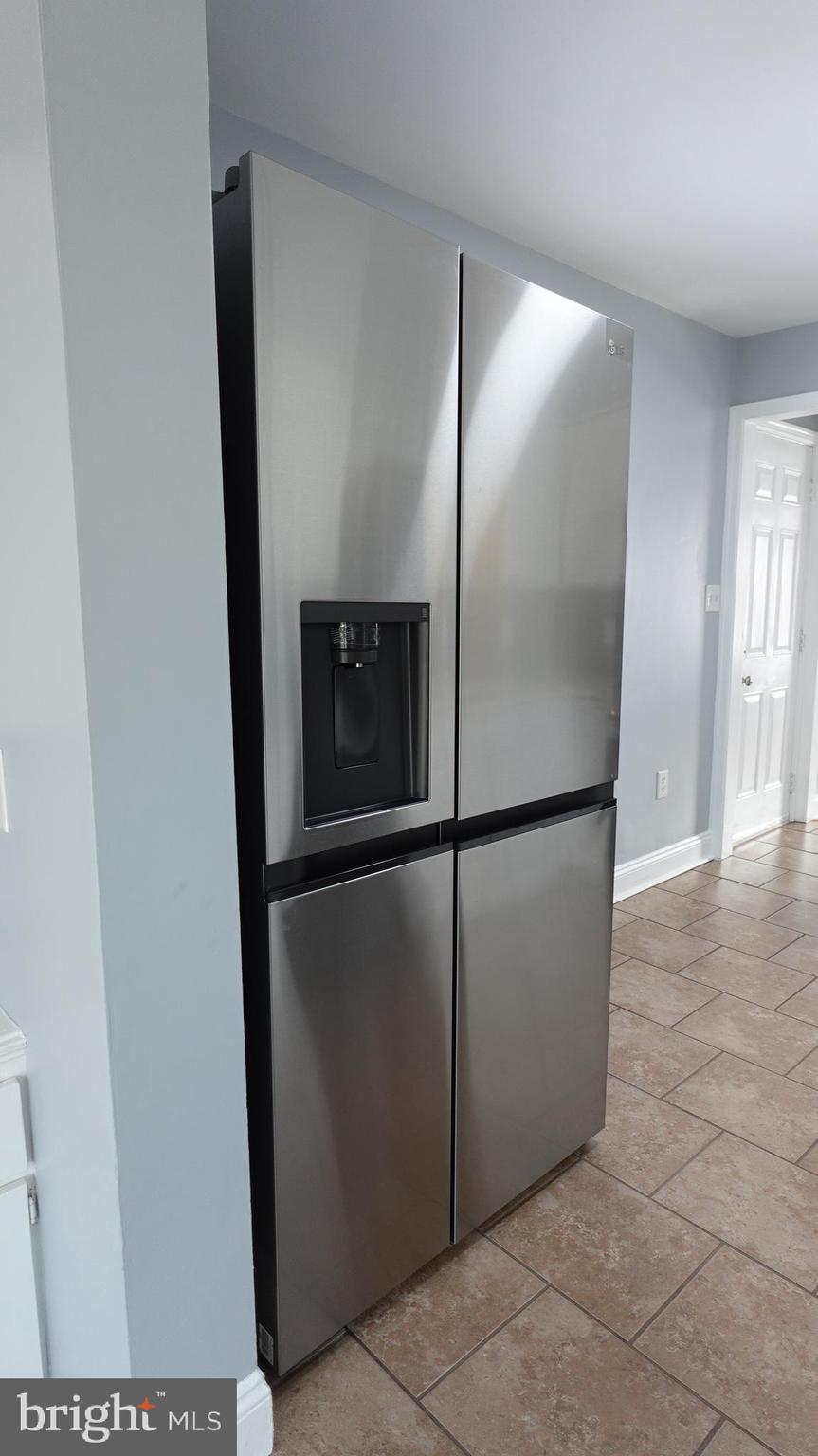 317 Devonshire Road Hagerstown, MD 21740 - Photo 5 of 114 a view of a refrigerator in kitchen and an empty room in wooden floor