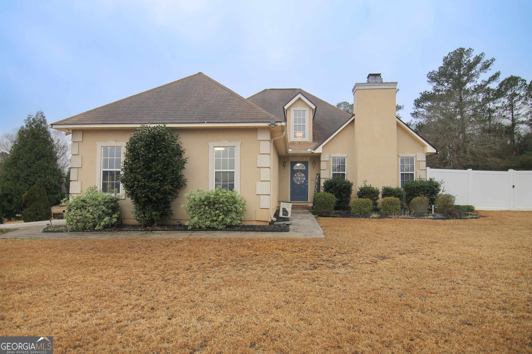 a front view of house with yard and trees around