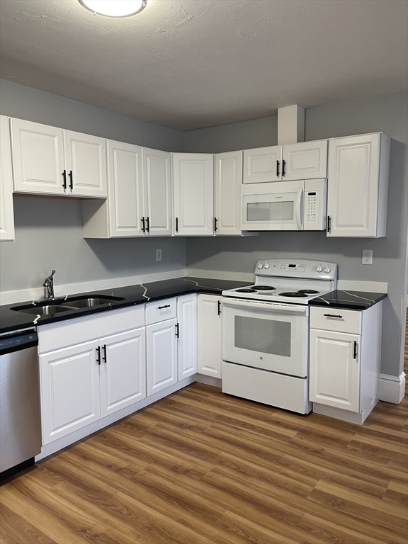 12 Winslow Street Worcester, MA 01609 - Photo 3 of 15 a white kitchen with granite countertop white cabinets and white appliances