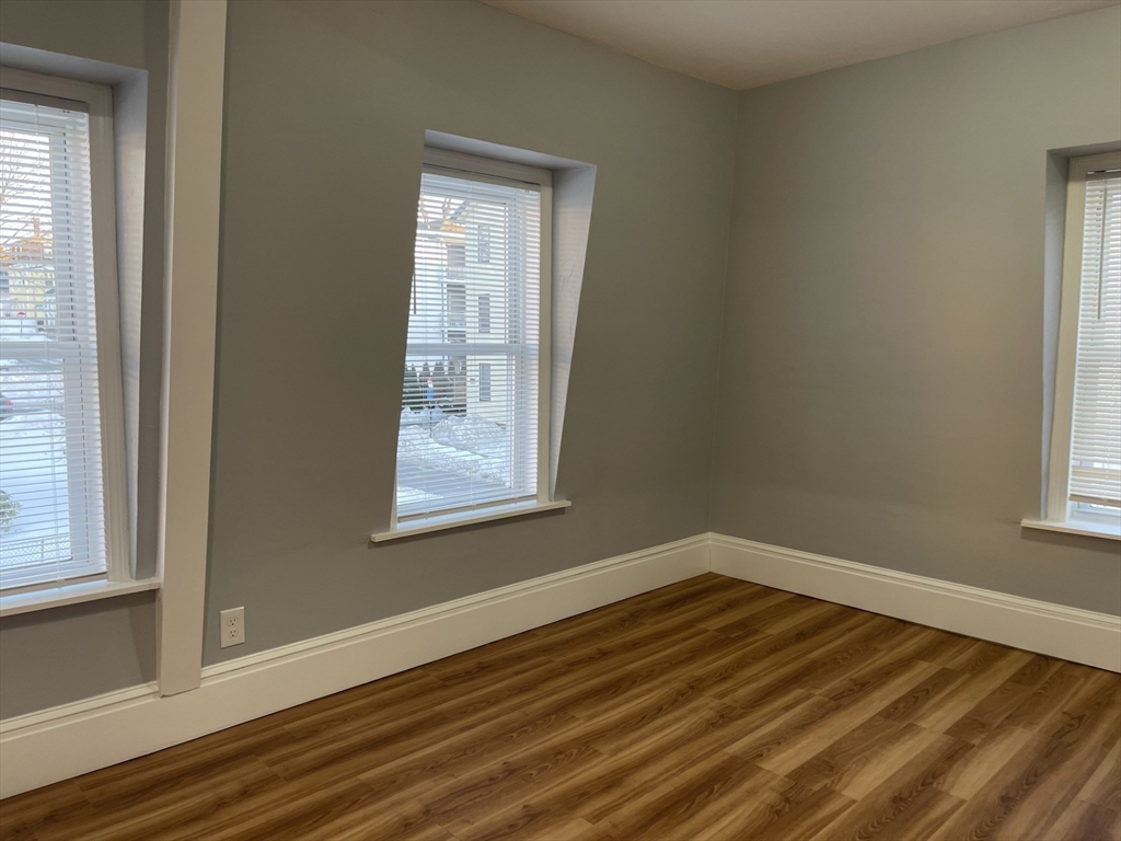 12 Winslow Street Worcester, MA 01609 - Photo 10 of 15 an empty room with wooden floor and windows