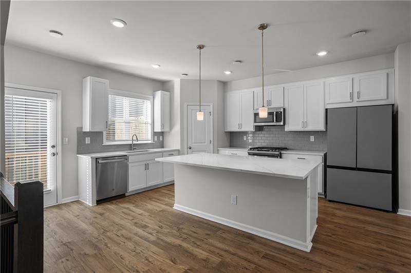 123 Matson Run Southwest Mableton, GA 30126 - Photo 15 of 32 a kitchen with kitchen island white cabinets and refrigerator