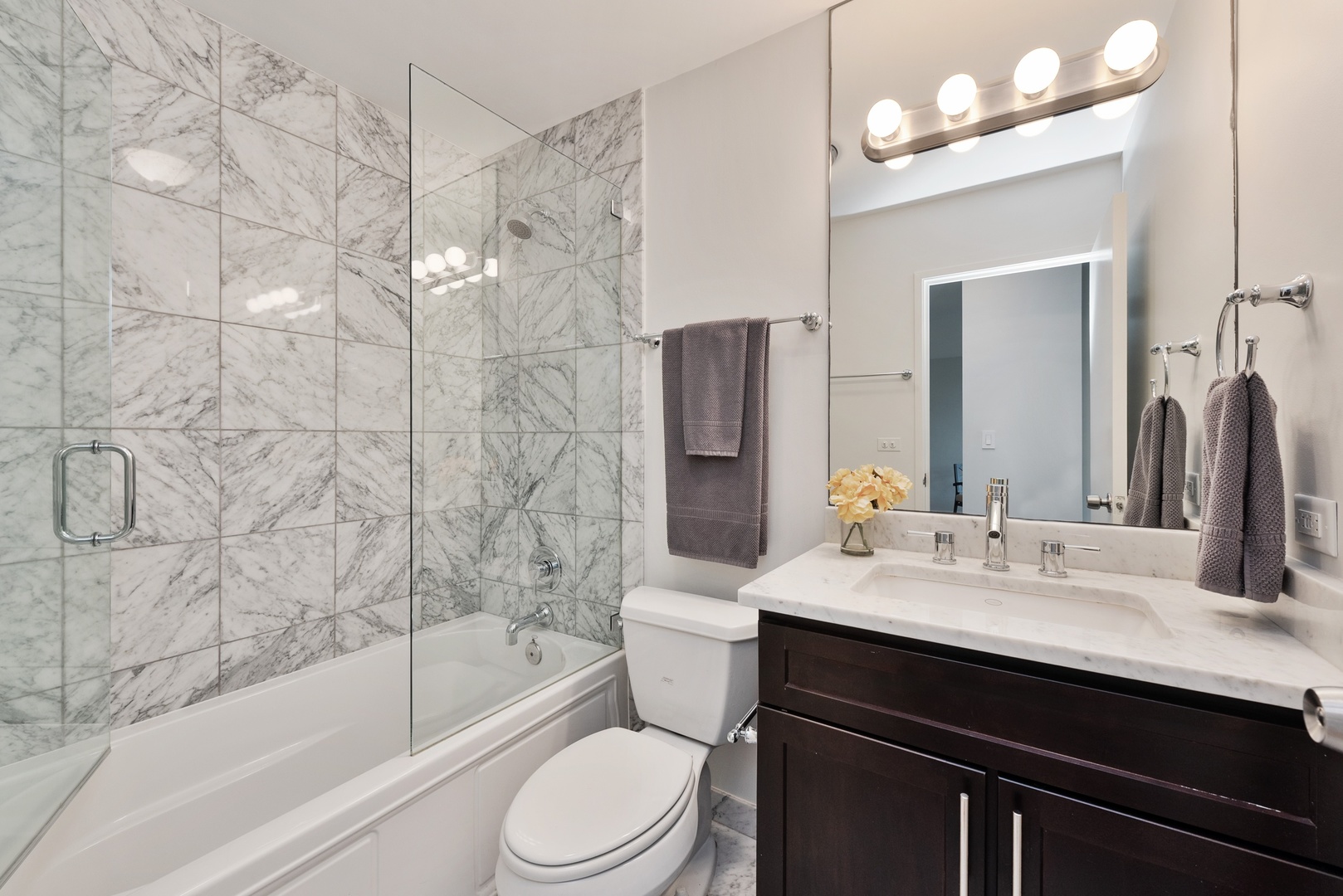 1920 North Clark Street, Unit 4B Chicago, IL 60614 - Photo 13 of 21 a bathroom with a bathtub sink vanity mirror and toilet