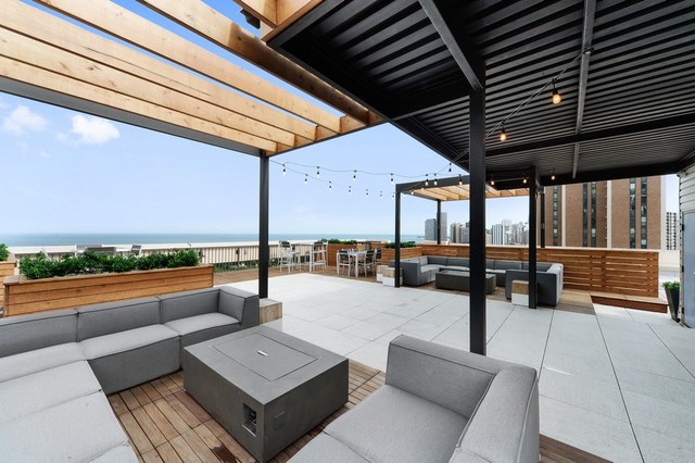 1920 North Clark Street, Unit 4B Chicago, IL 60614 - Photo 17 of 21 a view of a patio with a table and chairs with wooden floor and fence