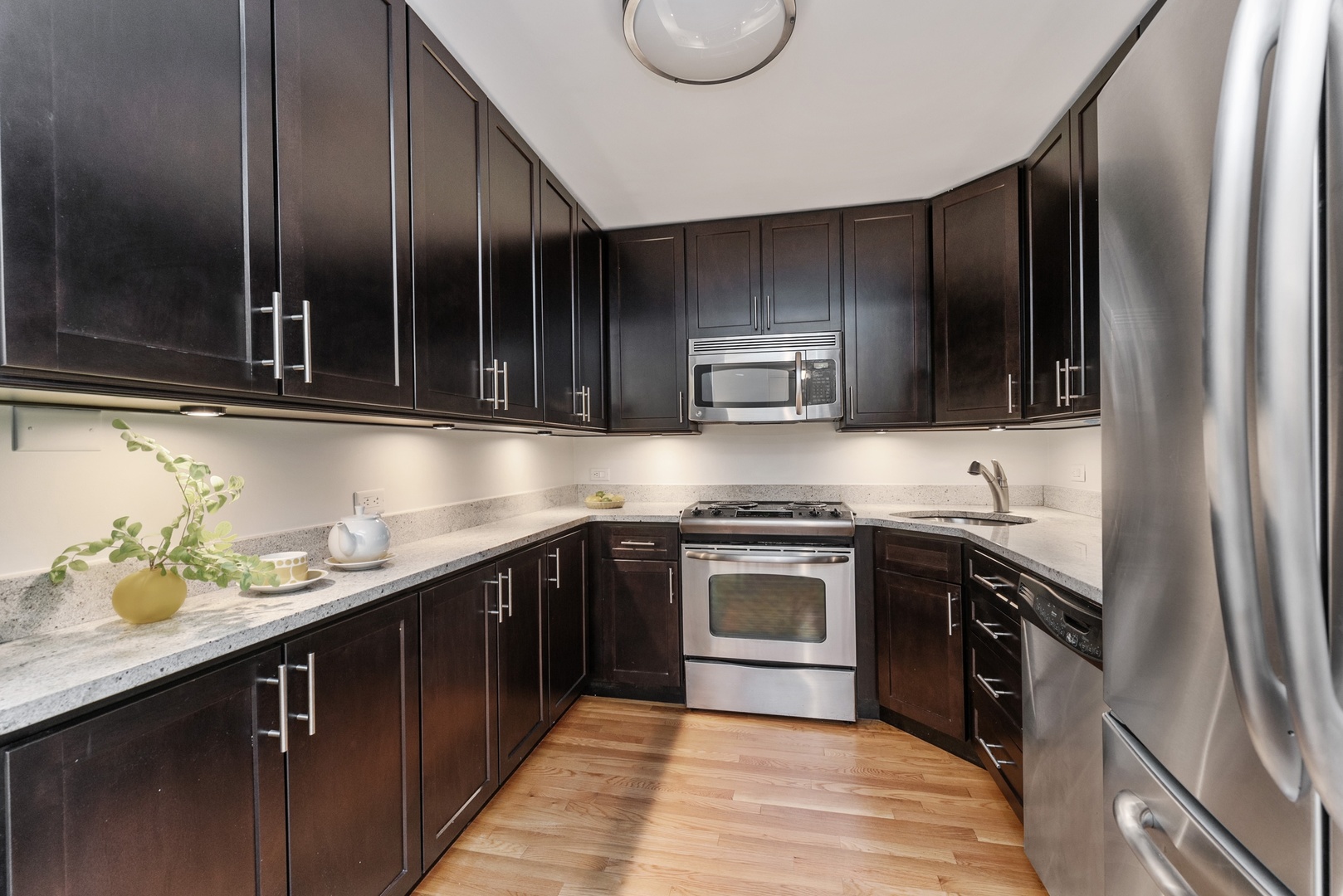 1920 North Clark Street, Unit 4B Chicago, IL 60614 - Photo 5 of 21 a kitchen with stainless steel appliances granite countertop a sink a stove and a refrigerator