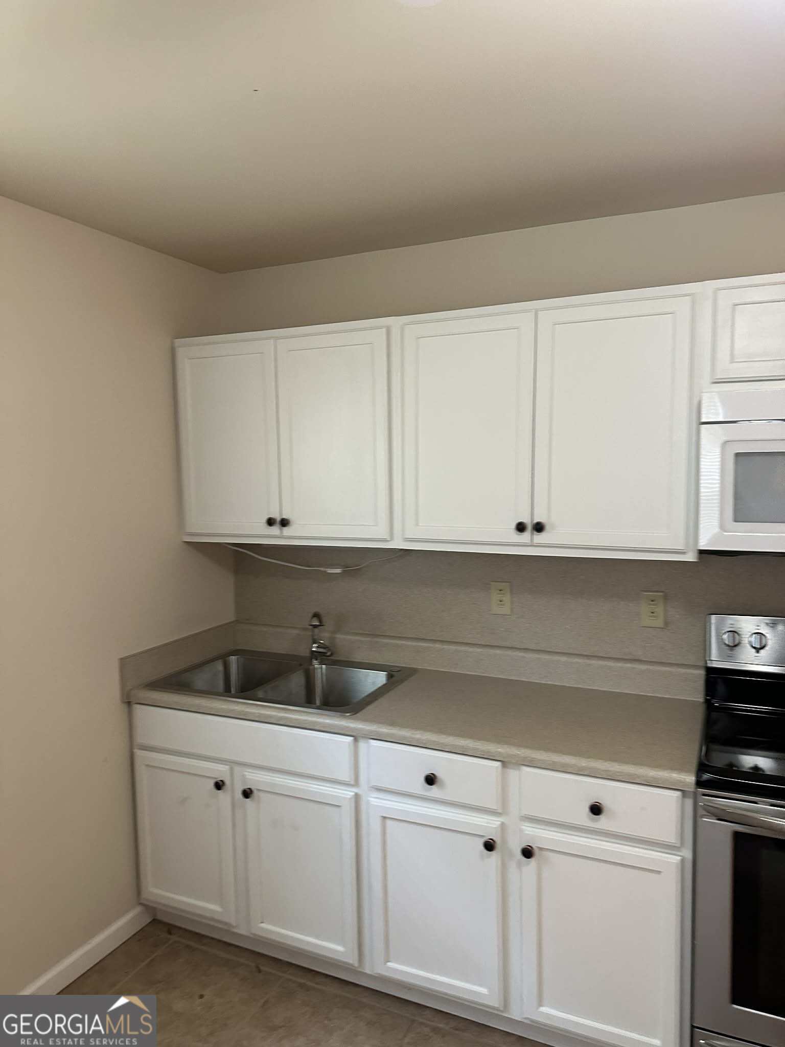 1167 Turner Way, Unit A Macon, GA 31217 - Photo 7 of 10 a kitchen with white cabinets and sink
