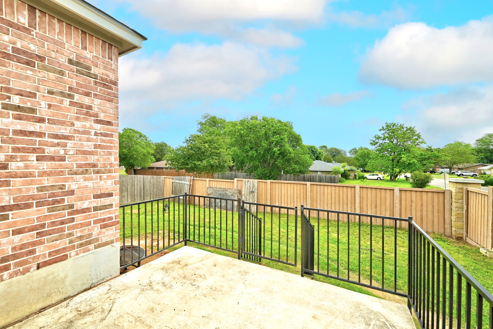 1621 Dragonfly Loop Bastrop, TX 78602 - Photo 23 of 27 Exterior brick siding with a concrete patio and black metal railing