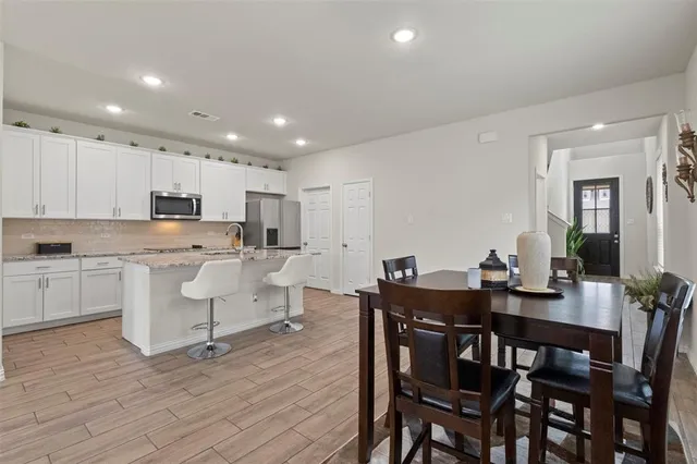 a view of kitchen with cabinets table and chairs